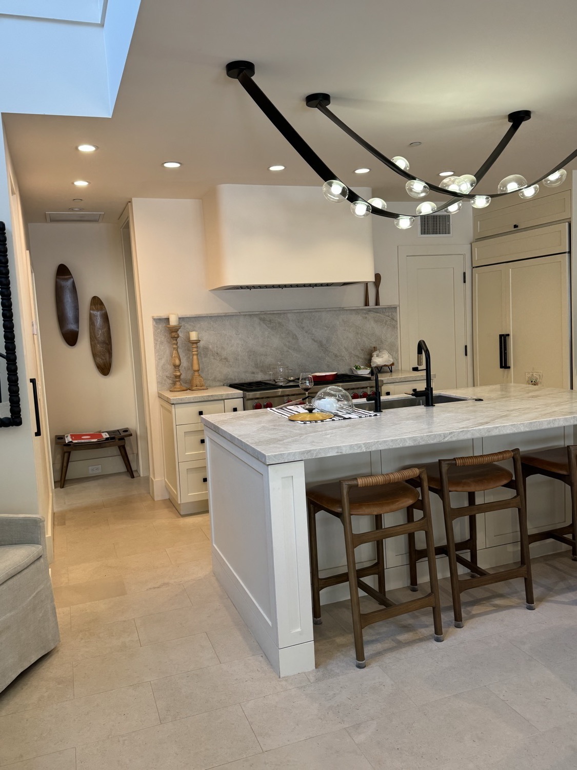 Open-concept chef's kitchen with marble waterfall island and bar seating